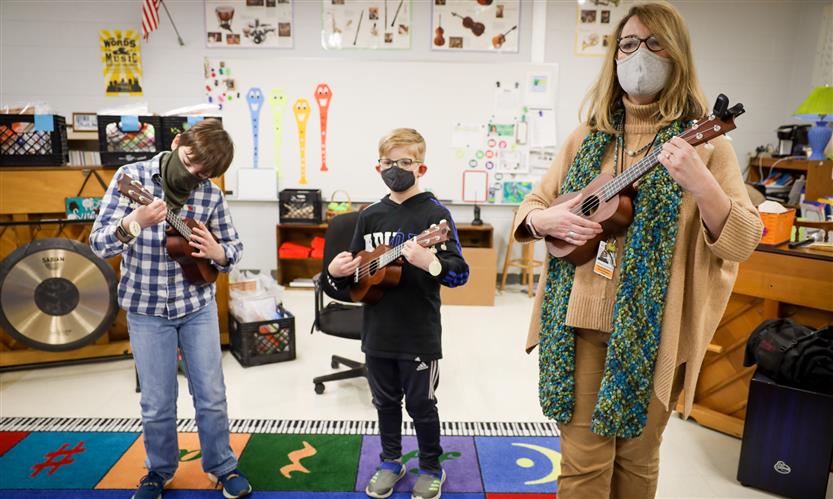 Students and teachers play ukuleles